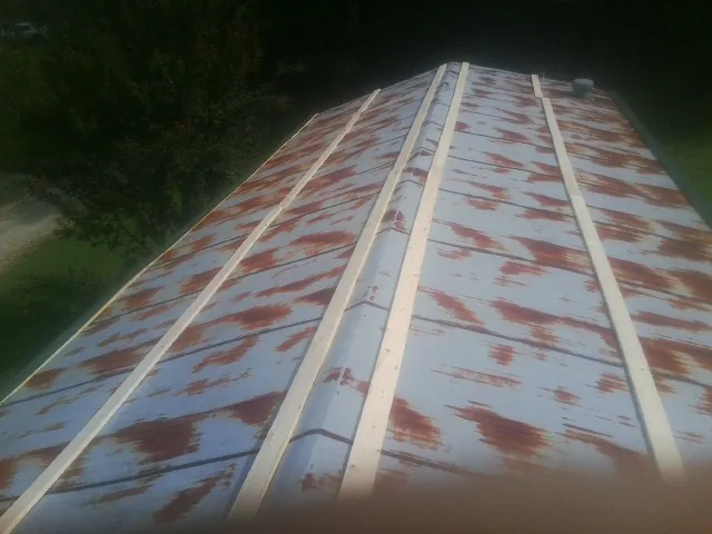 Rusted metal roof panels with new wood purlins before replacement — Storm Damage Roof Repair in Mattituck by Roofing Brothers