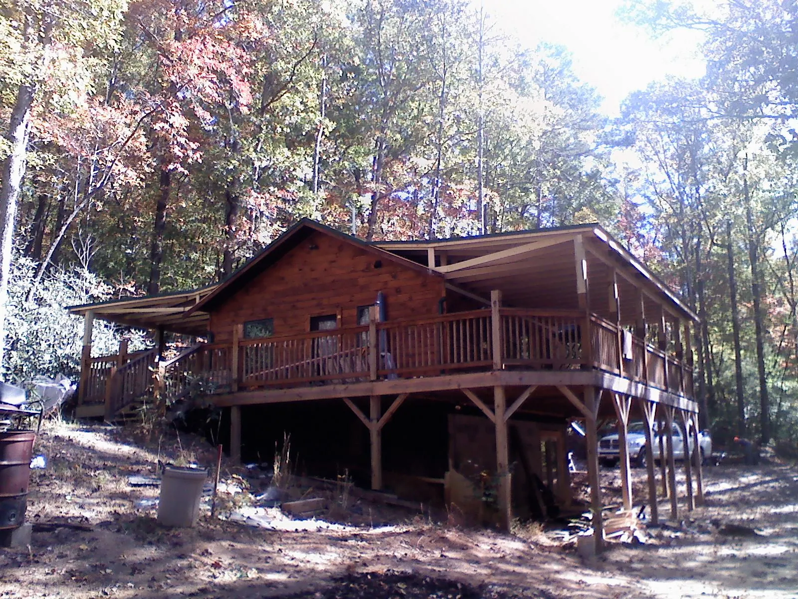 Log cabin with a wraparound porch and metal roof in the fall in Mattituck