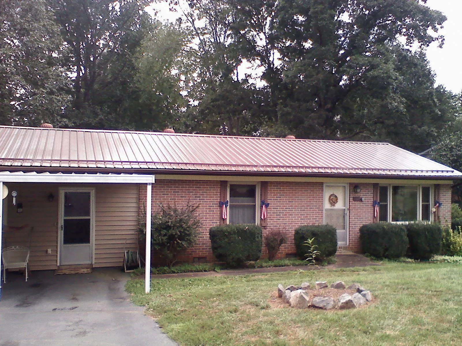 Bronze metal roof and carport on a brick ranch home — Roof Repair work by our crew in Mattituck
